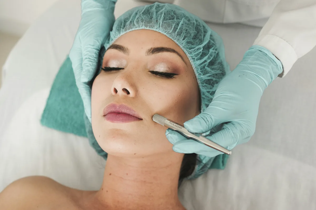 A clinician performing a precise aesthetic treatment with gloved hands